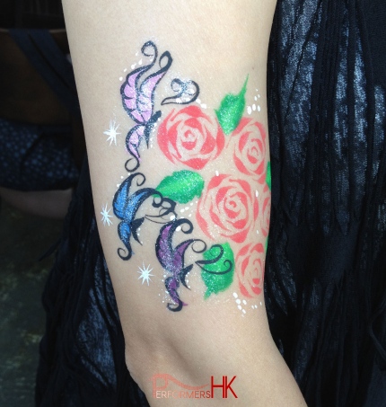 A guest from a corporate event requested the face painter in Hong  Kong draw a Butterfly and rose paints on her arm