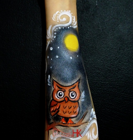 A creative arm paint with An owl standing on a tree in the night by a Hong Kong facepainter at a Halloween event. 