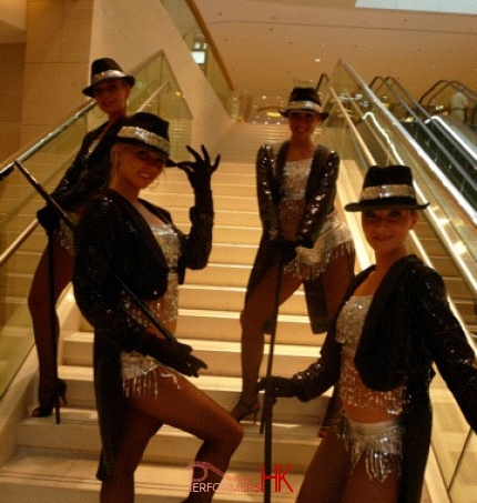 four dancers standing on staircase 