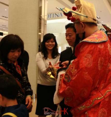 Performer dress as Choi Sun giving out red pocket to a shopping mall staff at a corporate event in Hong Kong