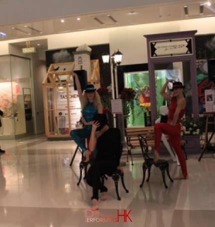 Three dancers in black, blue and red and wearing hats dancing in K11 mall