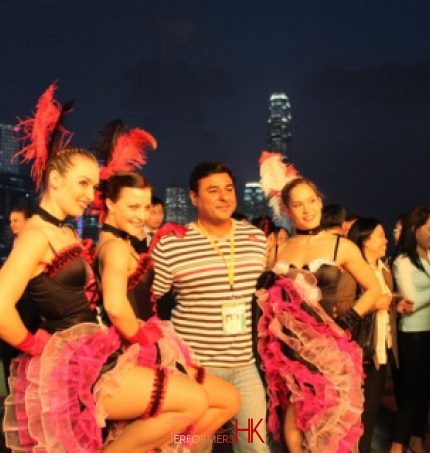 3 dancers with business person taking a photo with skyline of hk 