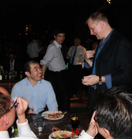 Walk around Magician in HK performing table card magic to four gentlemen at a roof top corporate event in Wan Chai