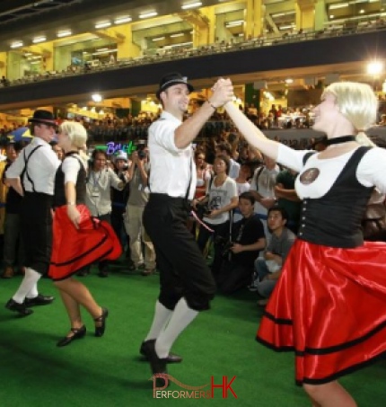 huge group of audience in Hong Kong jockey club watching four German dancers dancing at Oktoberfest Celebrations