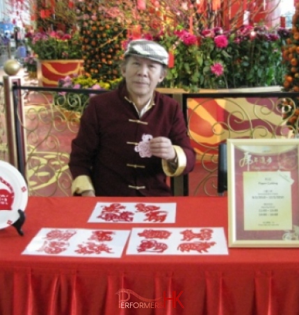 sifu wearing traditional chinese outfit cutting zodiac cuttings at hong kong airport for chinese new year