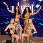 Four Hong Kong  Bollywood Dancer wearing gold and black costumes posing for a corporate event. 