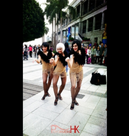 3 burlesque dancers posing in front of on-looking crowd