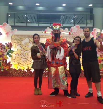 Two girls and a Man went up to the stage taking photo with Choi Sun Performer at a CNY event in Hong Kong Airport