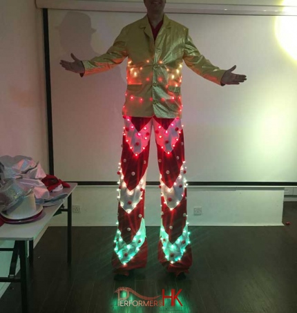 Stilt walker in Hong Kong lighting up his LED candy cane costume for photo