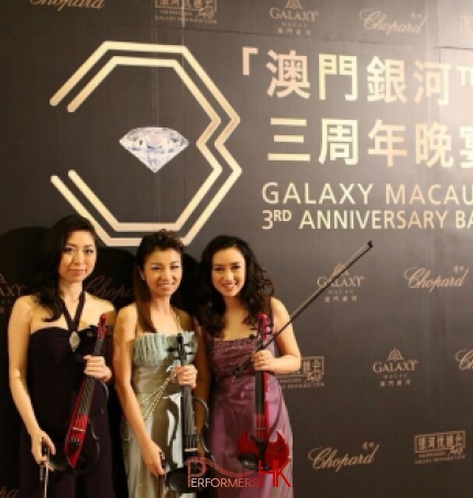 Violinists in Hong Kong taking photo in front of the backdrop before the Galaxy Macau 3RD Anniversary Ball start