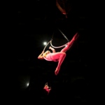 Female aerial performer manipulates her two hoops in midair.