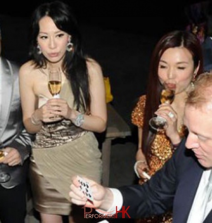 Magician performing table magic in front of the famous Hong Kong Kung Fu movie star and his model wife at a cocktails party  