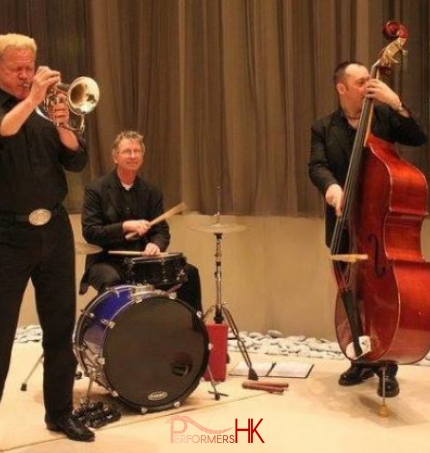 Three live band musicians performing at a Hong Kong realistic opening event