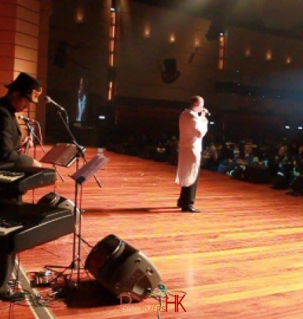 Hong Kong singer performing with a live band on stage at a Annual dinner