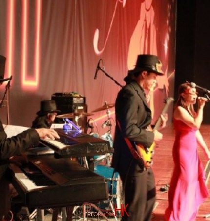 Singer in HK wearing pink , performing with live band at a annual event