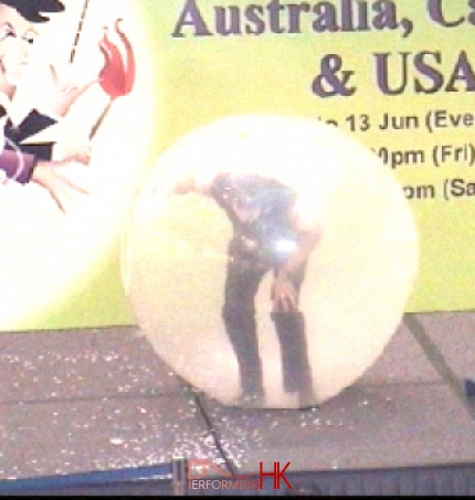 Hong Kong talented clown climbing inside a giant balloon at a shopping mall event.He is the only one to do this act in HK