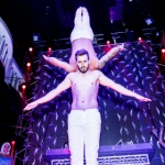 One of the Performer upside down and holding by other performer with his shoulder only. 