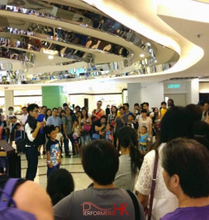 Hong Kong roving magician performing magic with a big audience at a Hong Kong shopping mall  