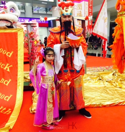 Hong Kong Choi Sun Performer taking photo with little Chinese Dance dancer at the airport. 