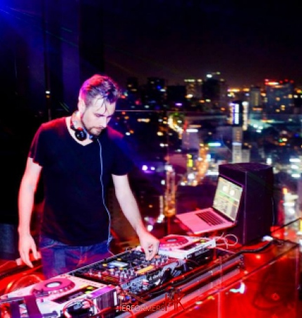 DJ Pure MB making music with night view of Hong Kong 