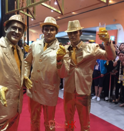 Three Hong Kong statue performers in gold costume at an annual event.