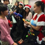 cory in lady santa costume twisting balloons for eager guests at hsbc private banking