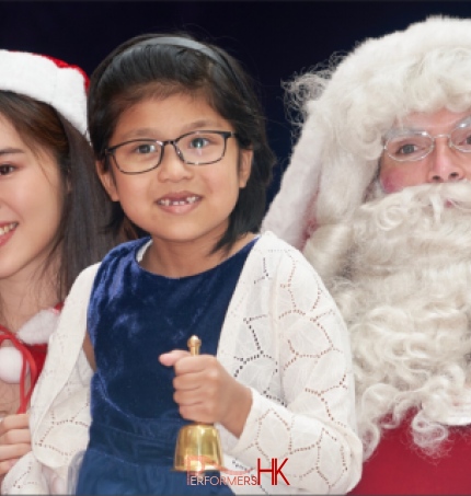 child holding bell in blue top with santa performer from performers hk