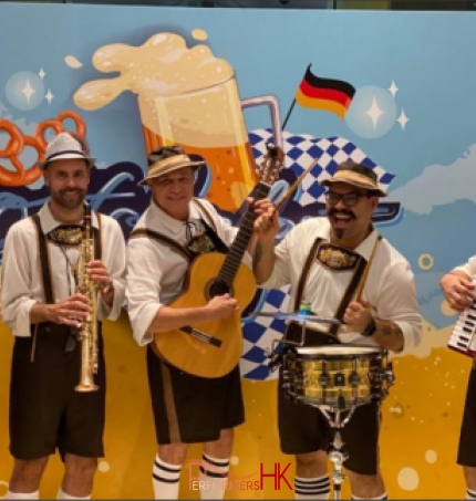 Band members jolly standing in front of a backdrop for oktoberfest for goald coast in tuen mum, hong kong