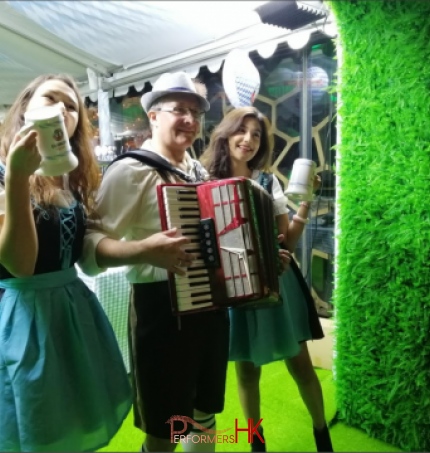 Accordion player in oktoberfest laderhosen with two models in tradtional bavarian beer girl costume at Ritz hong kong