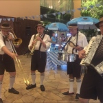 German band with brass, drums and accordion player in laderhousen outfit at an event