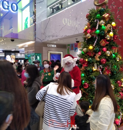 hong kong santa martin from the uk in front of christmas tree taking photos with crowd