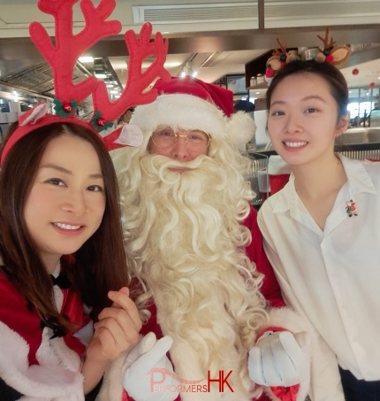 santa in red costume with santa girl in red costume, next to a waitress in central resturant booking with Pirata group in Hong Kong for Dec 2023, xmas hong kong 2023