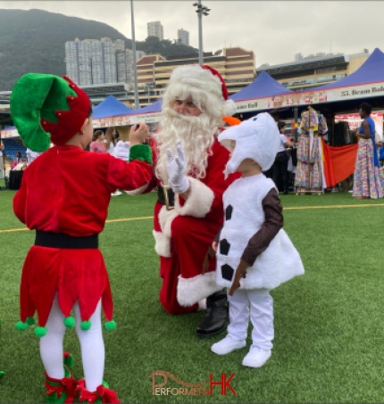 Santa in red costume with child in elf costume and child in snowman costume at sports road, causeway bay hong kong, hong kong football club