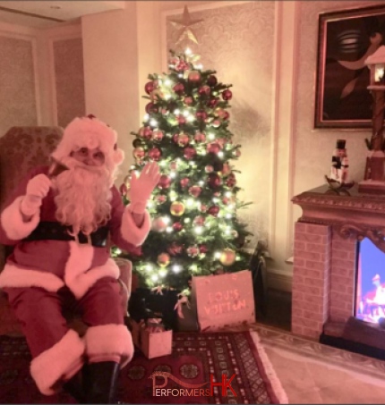 Santa sitting in front of fire place at American club tai tam event in Hong Kong